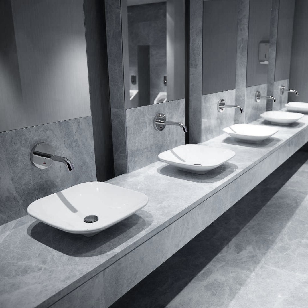 Architectural commercial restroom with wall mounted touchless faucets